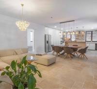 NA PREDAJ 4 IZB RD S DVOJGARÁŽOU, DUNAJSKÁ STREDA - Obývacia izba v rodinnom dome s kameňovou podlahou, veľkou sedačkou a jedálenským stolom.