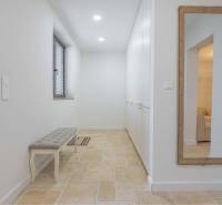 NA PREDAJ 4 IZB RD S DVOJGARÁŽOU, DUNAJSKÁ STREDA - Úzka chodba v rodinnom dome so zrkadlom, úložným priestorom a lavicou na dlažbe.