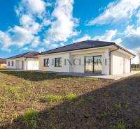 NA PREDAJ 4 IZBOVÝ RODINNÝ DOM-NOVOSTAVBA, KRÁĽOV BROD - Rodinný dom s bielou fasádou a tmavou strechou uprostred zelenej lúky.