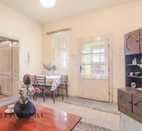 NA PREDAJ 4-IZBOVÝ RODINNÝ DOM NA PRIESTRANNOM POZEMKU - Interiér rodinného domu s drevenou nábytkom, stolom, kvetmi a dekoráciami.