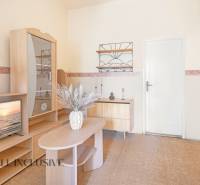 NA PREDAJ 4-IZBOVÝ RODINNÝ DOM NA PRIESTRANNOM POZEMKU - Obývacia izba s dreveným nábytkom, televízorom a dekoráciou v rodinnom dome.