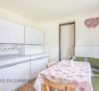 NA PREDAJ RODINNÝ DOM NA 9,5 ÁROVOM POZEMKU, OHRADY - Kuchyňa rodinného domu s bielymi skrinkami, kvetinovým obrusom a dekoráciou v tvare srdca.