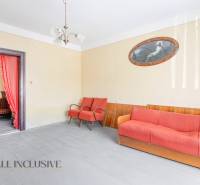 NA PREDAJ RODINNÝ DOM NA 9,5 ÁROVOM POZEMKU, OHRADY - Obývačka v rodinnom dome s oranžovou sedačkou, kreslami, obrázkom a lustrom.