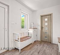 REZERVOVANÉ 3-IZBOVÝ RODINNÝ DOM V OBCI BALOŇ - Vstupná hala v rodinnom dome s bielym nábytkom a podlahou s dreveným dekorom.