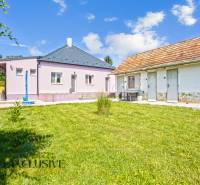 REZERVOVANÉ 3-IZBOVÝ RODINNÝ DOM V OBCI BALOŇ - Rodinný dom v Baloni s trávnatou záhradou, vedľa hospodárske budovy pod modrou oblohou.