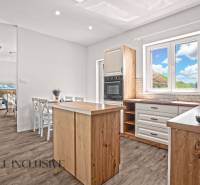 REZERVOVANÉ 3-IZBOVÝ RODINNÝ DOM V OBCI BALOŇ - Kuchyňa rodinného domu s dreveným nábytkom, podlahou s dreveným dekorom a jedálenským stolom.