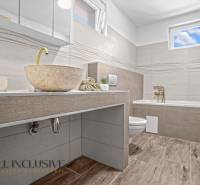 REZERVOVANÉ 3-IZBOVÝ RODINNÝ DOM V OBCI BALOŇ - Kúpeľňa v rodinnom dome s kamenným umývadlom a podlahou s dreveným dekorom.