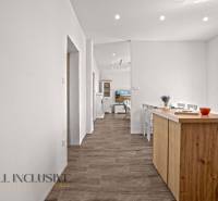 REZERVOVANÉ 3-IZBOVÝ RODINNÝ DOM V OBCI BALOŇ - Kuchyňa v rodinnom dome s podlahou s dreveným dekorom a bielym nábytkom.