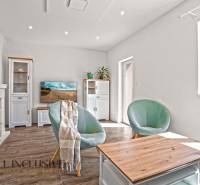 REZERVOVANÉ 3-IZBOVÝ RODINNÝ DOM V OBCI BALOŇ - Obývačka v rodinnom dome s pohodlnými kreslami, stolíkom a podlahou s dreveným dekorom.