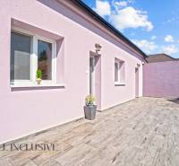 REZERVOVANÉ 3-IZBOVÝ RODINNÝ DOM V OBCI BALOŇ - Rodinný dom v Baloni s fialovou fasádou a podlahou s dreveným dekorom.