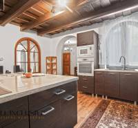 REZERVOVANÉ ZREKONŠTR. 6 IZBOVÝ RODINNÝ DOM, KOŠÚTY - Kuchyňa v rodinnom dome s podlahou s dreveným dekorom a klenutým oknom.