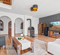 REZERVOVANÉ ZREKONŠTR. 6 IZBOVÝ RODINNÝ DOM, KOŠÚTY - Obývacia izba v rodinnom dome s krbom, oblúkovými dverami a podlahou s dreveným dekorom.