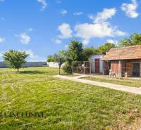 REZERVOVANÉ ZREKONŠTR. 6 IZBOVÝ RODINNÝ DOM, KOŠÚTY - Záhrada rodinného domu v Košútoch s dreveným domčekom a udržiavaným trávnikom.