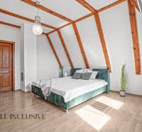 REZERVOVANÉ ZREKONŠTR. 6 IZBOVÝ RODINNÝ DOM, KOŠÚTY - Svetlá spálňa s posteľou, drevenými trámami a podlahou s dreveným dekorom v rodinnom dome.