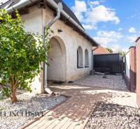 REZERVOVANÉ ZREKONŠTR. 6 IZBOVÝ RODINNÝ DOM, KOŠÚTY - Rodinný dom v Košútoch s arkádami, predzáhradkou s kamenivom a stromom, jasný deň.