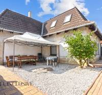 REZERVOVANÉ ZREKONŠTR. 6 IZBOVÝ RODINNÝ DOM, KOŠÚTY - Rodinný dom v Košútoch s terasou, altánkom a kamienkovým dvorom pod modrou oblohou.