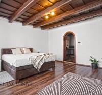 REZERVOVANÉ ZREKONŠTR. 6 IZBOVÝ RODINNÝ DOM, KOŠÚTY - Spálňa v rodinnom dome s oblúkovými dverami, posteľou a podlahou s dreveným dekorom.