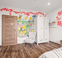 NA PREDAJ 4-IZB NOVOSTAVBA S TROJGARÁŽOU, PIN. KRAČANY - Detská izba s farebnou nástennou maľbou, skriňou a podlahou s dreveným dekorom v rodinnom dome.