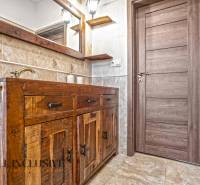 NA PREDAJ 4-IZB NOVOSTAVBA S TROJGARÁŽOU, PIN. KRAČANY - Kúpeľňa v rodinnom dome s dreveným dekorom a rustikálnym nábytkom.