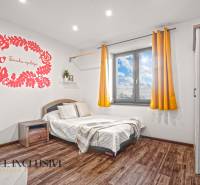 NA PREDAJ 4-IZB NOVOSTAVBA S TROJGARÁŽOU, PIN. KRAČANY - Spálňa v rodinnom dome s posteľou, nástennou dekoráciou a podlahou s dreveným dekorom.