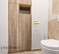 NA PREDAJ 4-IZB NOVOSTAVBA S TROJGARÁŽOU, PIN. KRAČANY - Toaleta v rodinnom dome s podlahou s dreveným dekorom a obkladom do polovice steny.