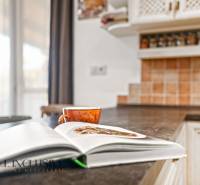 NA PREDAJ 4-IZB NOVOSTAVBA S TROJGARÁŽOU, PIN. KRAČANY - Otvorená kniha a šálka na kuchynskej linke v rodinnom dome.