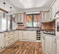 NA PREDAJ 4-IZB NOVOSTAVBA S TROJGARÁŽOU, PIN. KRAČANY - Kuchyňa v rodinnom dome s dreveným dekorom a béžovými skrinkami, svetlé a útulné.