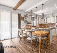 NA PREDAJ 4-IZB NOVOSTAVBA S TROJGARÁŽOU, PIN. KRAČANY - Kuchyňa rodinného domu s podlahou s dreveným dekorom a dreveným stolom.