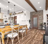 NA PREDAJ 4-IZB NOVOSTAVBA S TROJGARÁŽOU, PIN. KRAČANY - Jedáleň v rodinnom dome s podlahou s dreveným dekorom a tehlovou stenou.