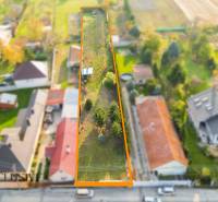 NA PREDAJ STAVEBNÝ POZEMOK (1524 m²), VYDRANY - Letecký pohľad na dlhý pozemok určený na bývanie vo Vydranoch, obklopený domami a zeleňou.