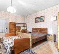 Na predaj 4-izbový rodinný dom, Dolné Saliby - Spálňa v rodinnom dome s vintage nábytkom a tapetami s kvetinovým vzorom.