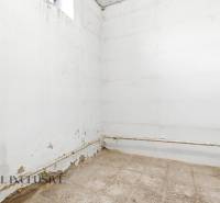 Na predaj 4-izbový rodinný dom, Dolné Saliby - Prázdna miestnosť s bielymi stenami a poškodenou podlahou v rodinnom dome.