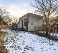 Na predaj 4-izbový rodinný dom, Dolné Saliby - Rodinný dom v Dolných Salibách, obklopený zimným snehom a zasneženými stromami.