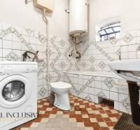 Na predaj 4-izbový rodinný dom, Dolné Saliby - Kúpeľňa v rodinnom dome s práčkou, vaňou a obkladmi.