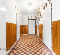 Na predaj 3-izbový rodinný dom, Dobrohošť - Chodba v rodinnom dome s poľovníckymi trofejami a dlaždicovou podlahou.