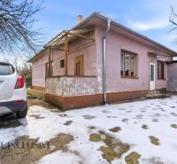 Na predaj 3-izbový rodinný dom, Dobrohošť - Rodinný dom v Dobrohošti s autom zaparkovaným na zasneženom dvore.