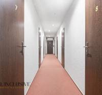 Na prenájom podnikateľské priestory, Senec - Hotelová chodba s číslovanými dverami a červeným kobercom.