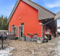 Na prenájom podnikateľské priestory, Senec - Exteriér hotela či penziónu v Senci so stoličkami a bicyklom pred oranžovou budovou.