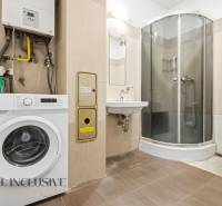 Na predaj 3-izbový byt so záhradkou, Senec - Kúpeľňa s práčkou, sprchovým kútom, umývadlom, toaletou a podlahou s dreveným dekorom.