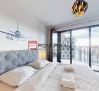 Na prenájom 2 izb. byt s parkovaním a veľkou terasou Guthaus - Spálňa v 2-izbovom byte s balkónom a dekorom lietadla na stene.