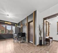 Na predaj 5-izb. rodinný dom na 50-á pozemku, Sap - Kuchyňa v rodinnom dome s podlahou s dreveným dekorom a veľkými oknami.