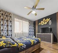 Na predaj 5-izb. rodinný dom na 50-á pozemku, Sap - Spálňa v rodinnom dome s farebnou posteľou, dreveným dekorom a výraznou nástennou výzdobou.