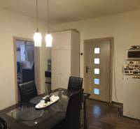 Na predaj 3-izb. rodinný dom, Gabčíkovo – Polná ulica - Jedáleň v rodinnom dome s čiernym stolom, stoličkami a podlahou s dreveným dekorom.
