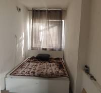 Na predaj 3-izb. rodinný dom, Gabčíkovo – Polná ulica - Spálňa v Rodinnom dome s posteľou, závesmi a podlahou s dreveným dekorom.