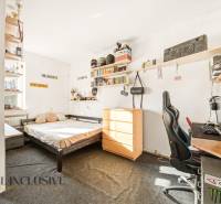 Na predaj 3-izb.rod.dom s dvojgarážou,Vojka nad Dunajom - Izba v rodinnom dome s posteľou, písacím stolom, regálmi a dekoráciami na stenách.