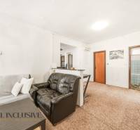 Na predaj 3-izb.rod.dom s dvojgarážou,Vojka nad Dunajom - Interiér rodinného domu s koženým kreslom, pohovkou a kobercom v obývacej izbe.