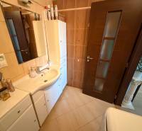 3 izbový byt s balkónom Topoľčany  - Kúpeľňa v 3-izbovom byte s bielym nábytkom a tmavými dverami.