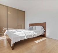 | Krásny a moderný 2-izbový byt | 51,50m² | - Spálňa v 2-izbovom byte s posteľou, vstavanou skriňou a podlahou s dreveným dekorom.
