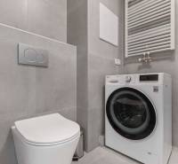 | Krásny a moderný 2-izbový byt | 51,50m² | - Kúpeľňa v 2-izbovom byte so sivými obkladačkami, toaletou a práčkou.