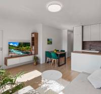 | Krásny a moderný 2-izbový byt | 51,50m² | - Obývacia izba 2-izbového bytu s podlahou s dreveným dekorom, televízorom a jedálenským stolom.